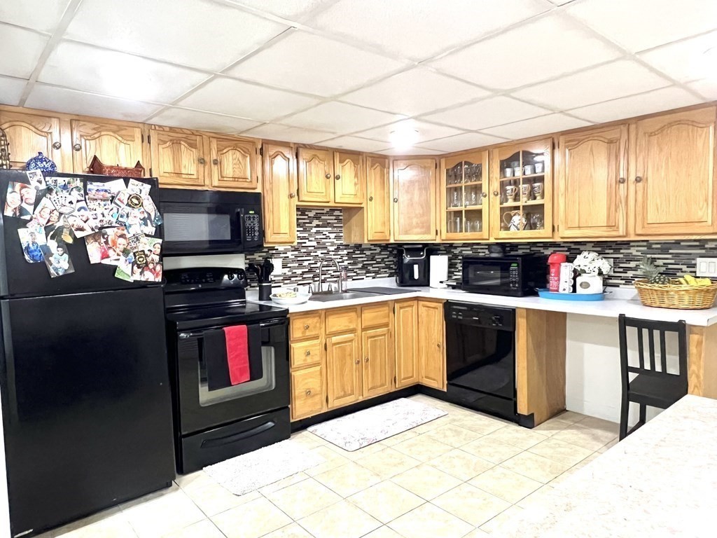 4 Shadowbrook Lane, Unit 6 Milford, MA 01757 - Photo 4 of 16 a kitchen with stainless steel appliances kitchen island granite countertop a stove a sink and a microwave
