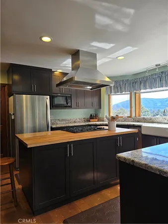 a kitchen with stainless steel appliances granite countertop a sink a stove and a refrigerator