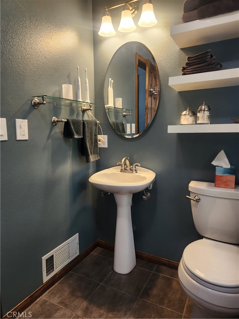 1014 Dusty Road Frazier Park, CA 93225 - Photo 25 of 40 a bathroom with a toilet sink and mirror
