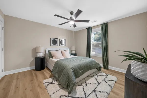 a bedroom with a large bed and a chandelier