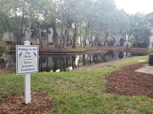 a view of a street sign under a large tree