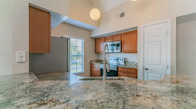 a kitchen with stainless steel appliances granite countertop a sink stove and refrigerator
