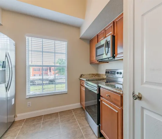 a kitchen with granite countertop cabinets and window