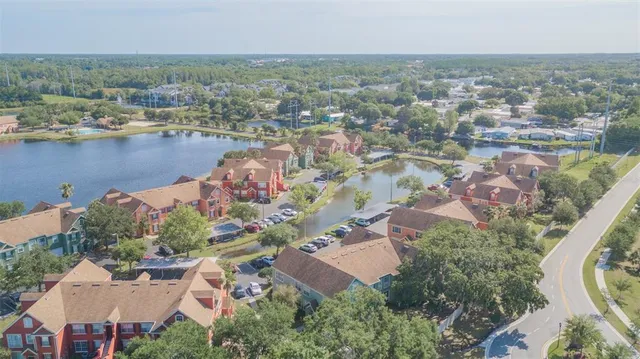 an aerial view of residential houses with outdoor space and lake view