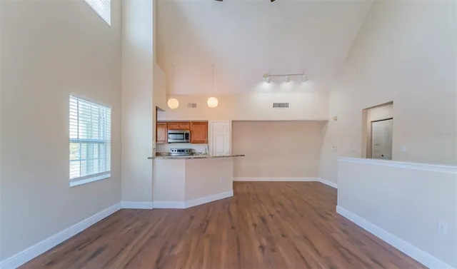 a view of a kitchen with wooden floor and a window