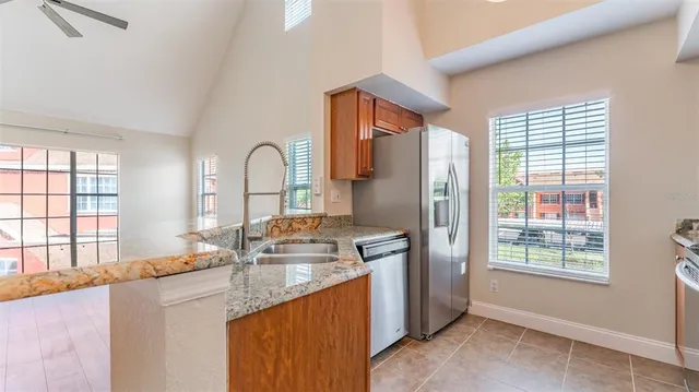 a kitchen with granite countertop a stove a sink and a microwave