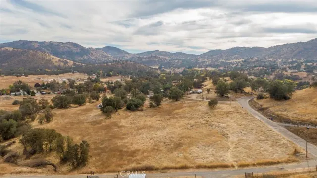 a view of a dry yard with mountains in the background