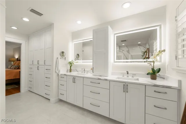 a en suite bathroom with double sink and a mirror
