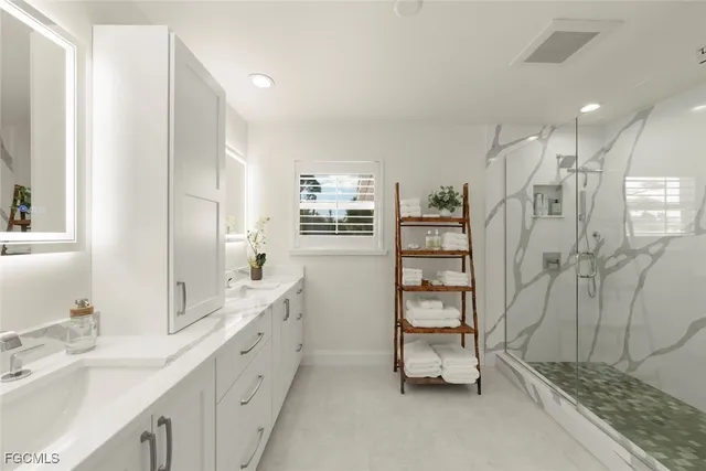a bathroom with a double vanity sink a toilet and shower