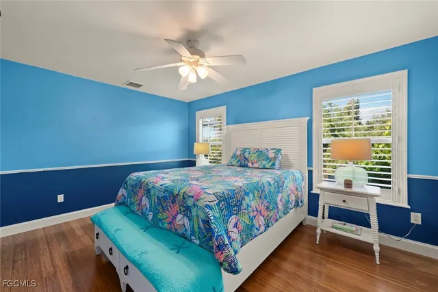 a room with a bookshelf a table and chairs in it