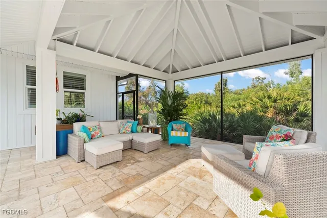 a living room with patio furniture and a floor to ceiling window