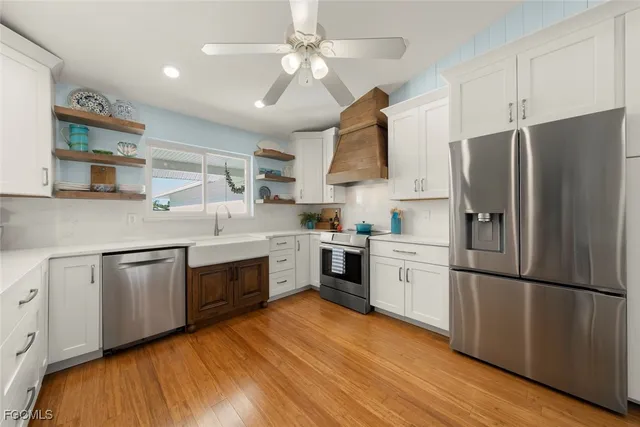 a kitchen with white cabinets stainless steel appliances and a window