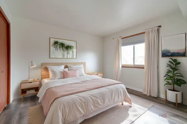 a bedroom with a bed and a potted plant
