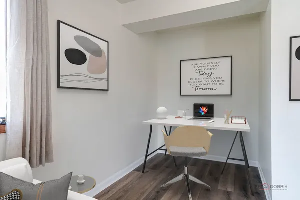 a view of a workspace with furniture and wooden floor