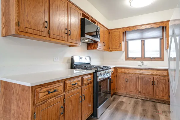a kitchen with stainless steel appliances granite countertop a sink stove and cabinets