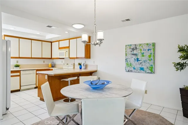 a view of kitchen with granite countertop sink table and chairs