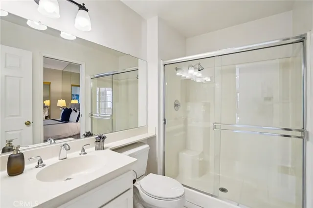 a bathroom with a sink toilet mirror and shower