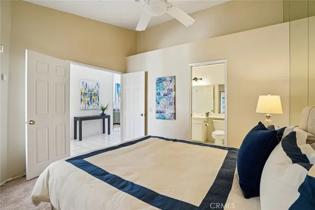 a bedroom with a bed and a lamp on dresser