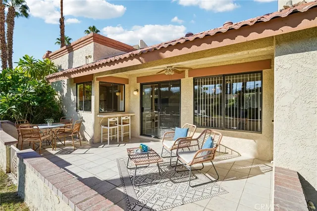 a view of a patio with couches table and chairs with wooden floor