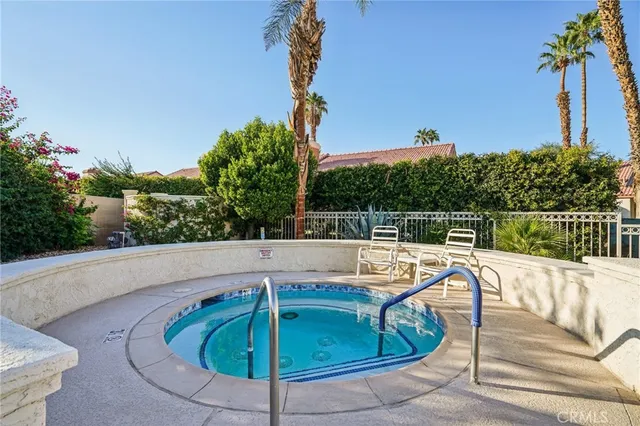 a view of a swimming pool with a lawn chairs under an umbrella