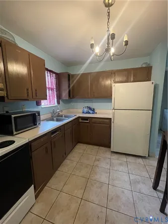 a kitchen with a sink a refrigerator and cabinets