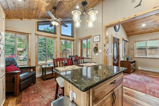 a dining room with granite countertop a couch and chandelier