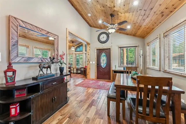 a view of a dining room and livingroom with furniture large window wooden floor and a clock