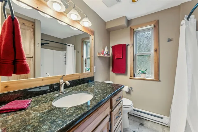a bathroom with a granite countertop sink and a mirror