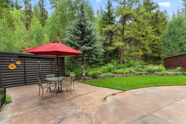 a patio with a table and chairs under an umbrella