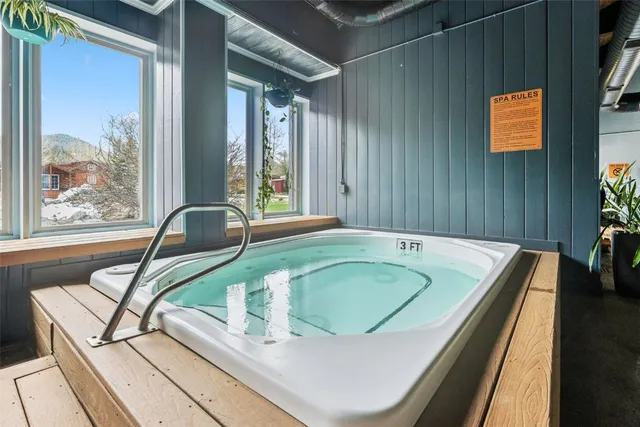 a bathroom with a tub sink and mirror