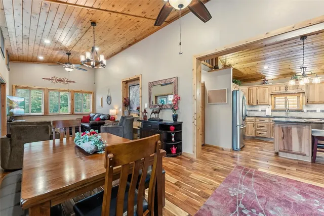 a view of a dining room and livingroom with furniture wooden floor a chandelier
