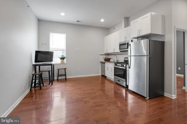 a kitchen with stainless steel appliances a refrigerator and a stove top oven