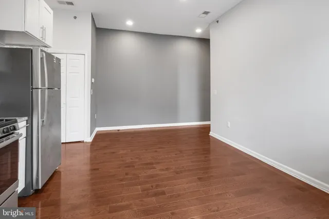 a view of empty room with wooden floor