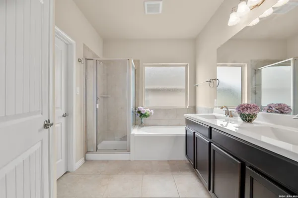 a bathroom with a sink a bathtub a mirror a vanity and a shower
