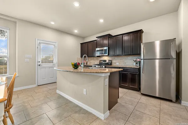 a kitchen with kitchen island a counter top stainless steel appliances and cabinets