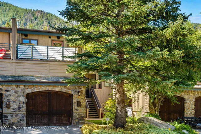 a front view of a house with plants