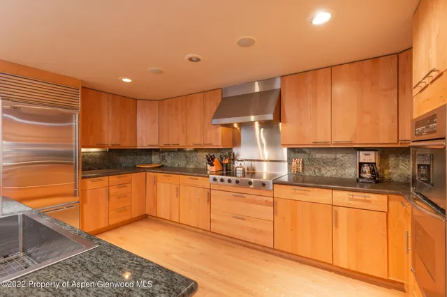 a kitchen with stainless steel appliances granite countertop a sink stove and cabinets