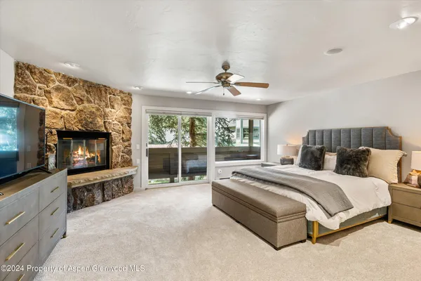 a spacious bedroom with a large bed and a flat screen tv