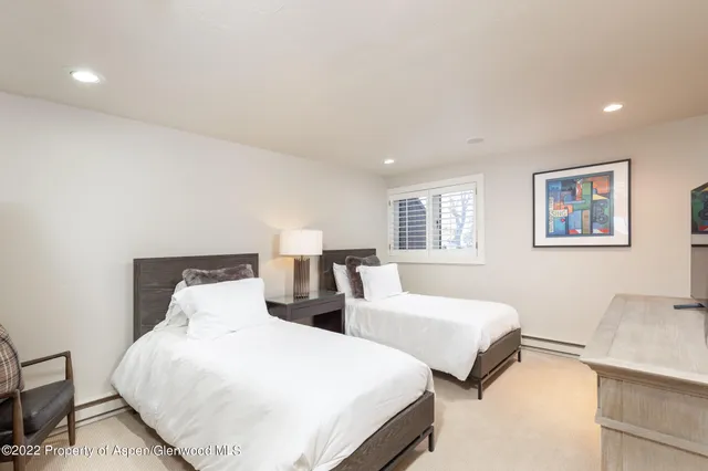 a bedroom with two beds and a night stand