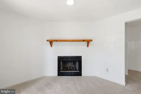 a view of an empty room with a window and fireplace