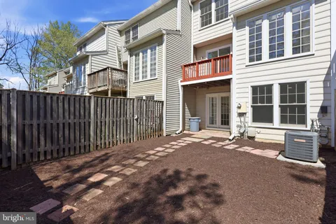 a view of a backyard with wooden fence and a bench