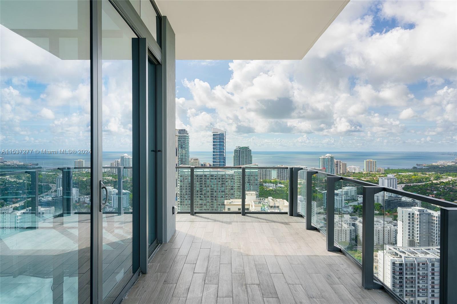 88 Southwest 7th Street, Unit 4001 Miami, FL 33130 - Photo 2 of 42 a view of a balcony with floor to ceiling windows with wooden floor