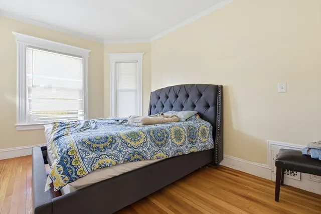 a bed sitting in a bedroom next to a window