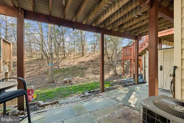 a porch with chairs next to a yard