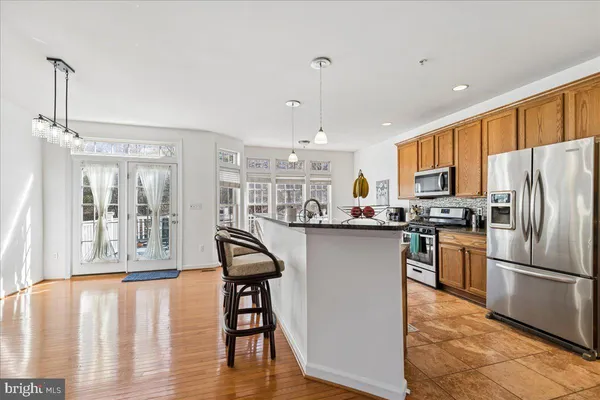 a kitchen with kitchen island a counter top space a sink appliances and cabinets