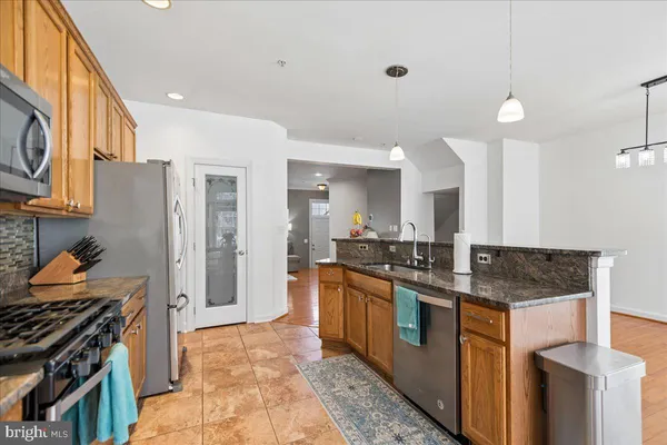a kitchen with stainless steel appliances granite countertop a stove and a sink