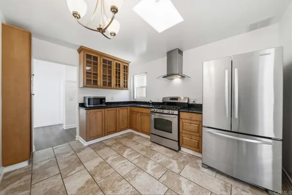 a kitchen with granite countertop a refrigerator and a stove top oven
