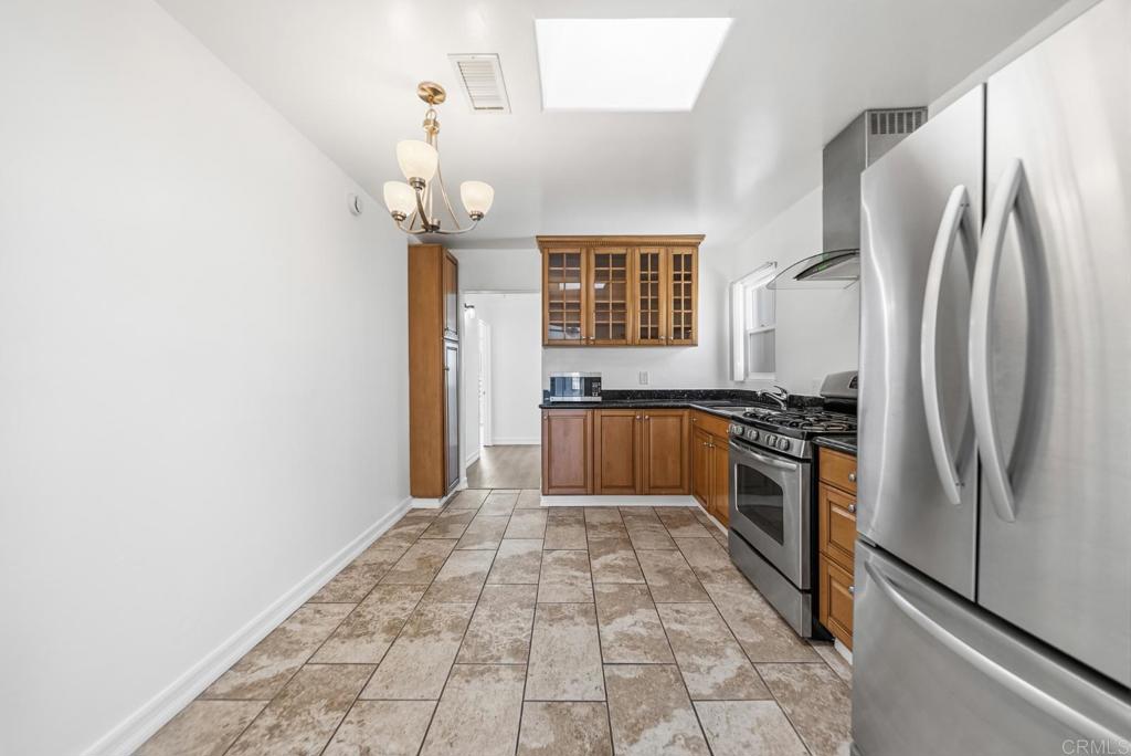 724 Felicita Avenue Spring Valley, CA 91977 - Photo 12 of 37 a kitchen with granite countertop a refrigerator and a stove top oven