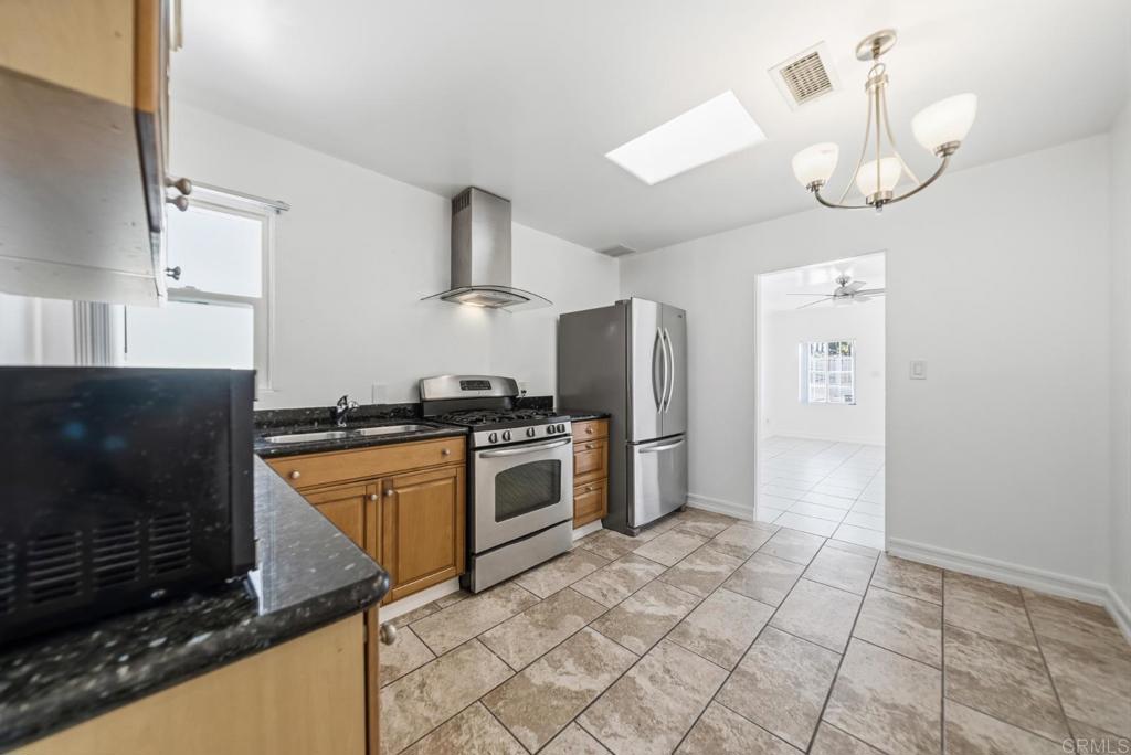724 Felicita Avenue Spring Valley, CA 91977 - Photo 6 of 37 a kitchen with stainless steel appliances granite countertop a stove a sink and a refrigerator
