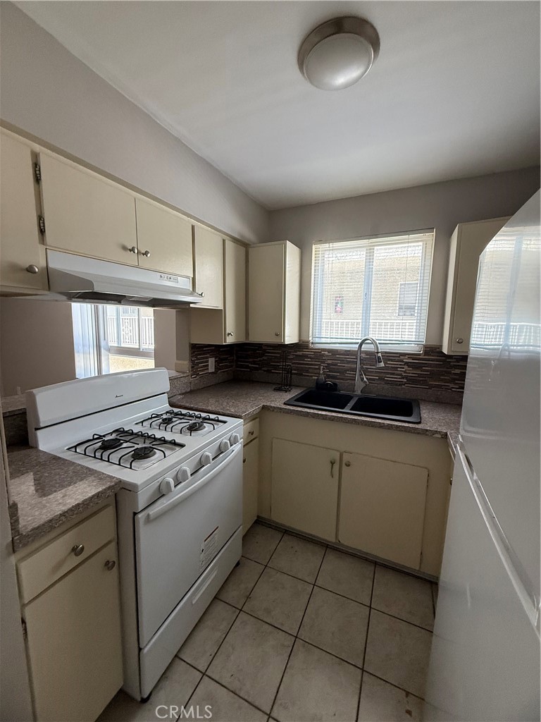 10900 Blix Street, Unit 4 North Hollywood, CA 91602 - Photo 3 of 10 a kitchen with granite countertop a sink a stove and cabinets